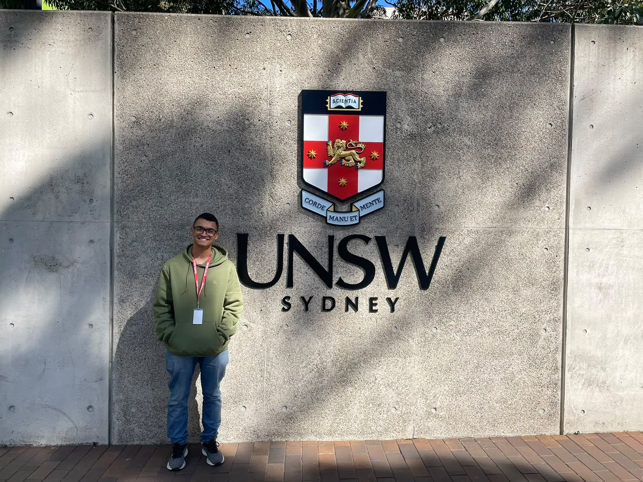 Lucas Santos em frente ao letreiro da UNSW Sydney